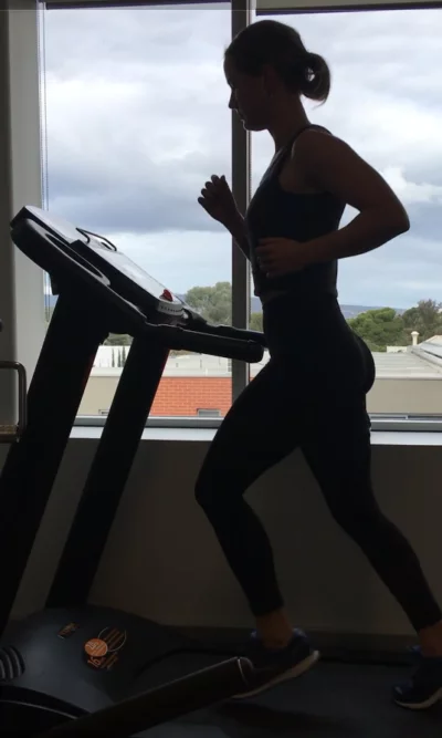 Runner silhouetted on a treadmill during a running assessment