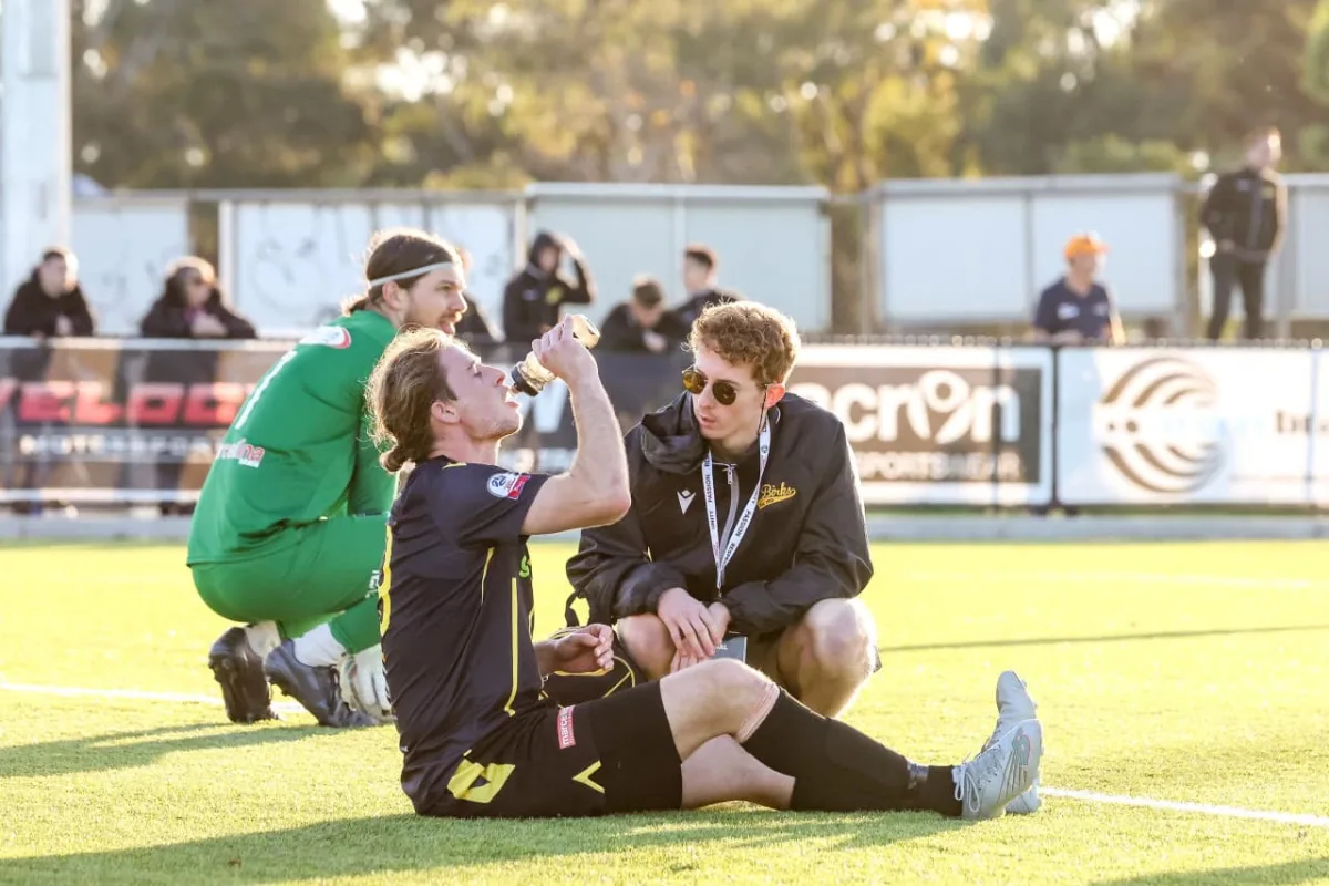 Saunders physiotherapists assessing a footballer on the sideline during a match